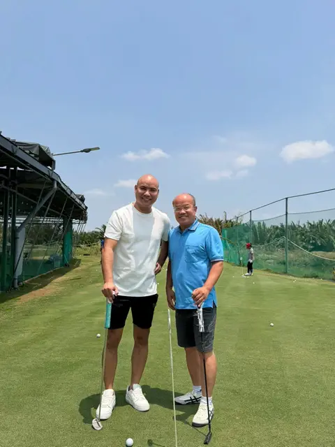 Two coaches on the driving range