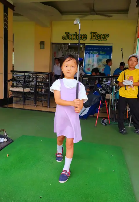 Bé gái váy tím cầm gậy