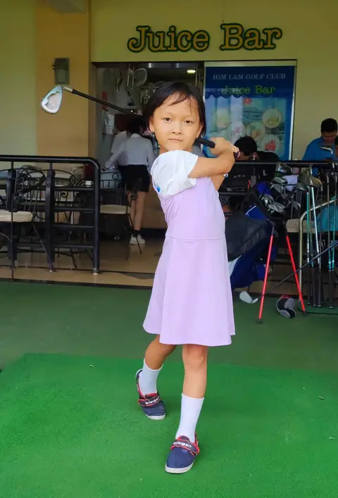 Bé gái tạo dáng vung gậy